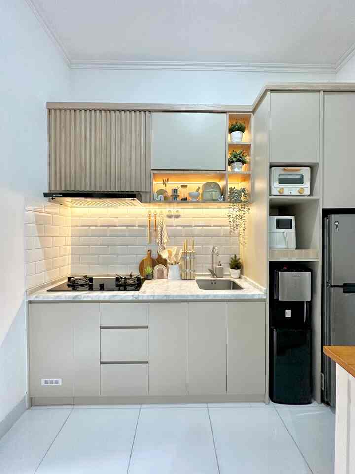 Natural modern kitchen space in soft beige and white tones, featuring cabinetry, gas stove, and sink with clean layout