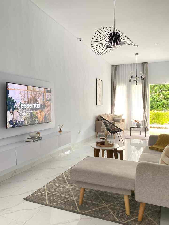 Modern living room in white and gray tones featuring comfortable sofa and round coffee tables with a simple atmosphere