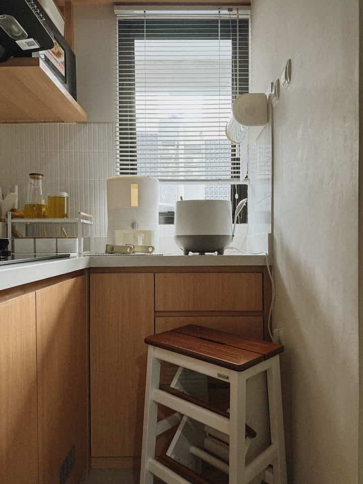 Siang hari di dapur Japandi #rumahdiakasia 🌤️

Dapur dengan style #Japandi yang didominasi oleh warna putih dan kayu di rumah kami ini semakin 'hidup' ketika sinar matahari alami masuk melalui jendela di siang hari, menciptakan vibes yang hangat dan tentram. 

Salah satu elemen yang menarik adalah tangga dapur kayu yang dapat dilipat dan multifungsi. Saat tidak digunakan sebagai tangga, ini bisa diubah menjadi kursi yang praktis dan estetik, sesuai dengan prinsip minimalis Japandi.

Salah satu sudur dinding dapur kami dihiasi dengan tempat tisu dapur roll yang ditempel langsung ke tembok, memberikan solusi hemat ruang dan tetap mudah dijangkau. Dispenser beras yang cantik juga ditempatkan bersebelahan dengan rice cooker, memudahkan akses tanpa mengorbankan estetika ruangan.

Barang lain yang sangat berguna di dapur kami adalah alas silikon lentur yang anti panas dan anti slip, sempurna untuk menempatkan alat masak panas tanpa khawatir merusak permukaan meja granit kitchen set kami.

Semoga menginspirasi! ☺️🫶🏻

#dapur #inspirasidapur #dapurcantik #dapursempit #dapurkayu #kitchenset #estetik #rumahmungil #rumahdeveloper #BSD #rumahcluster #rumahdiakasia