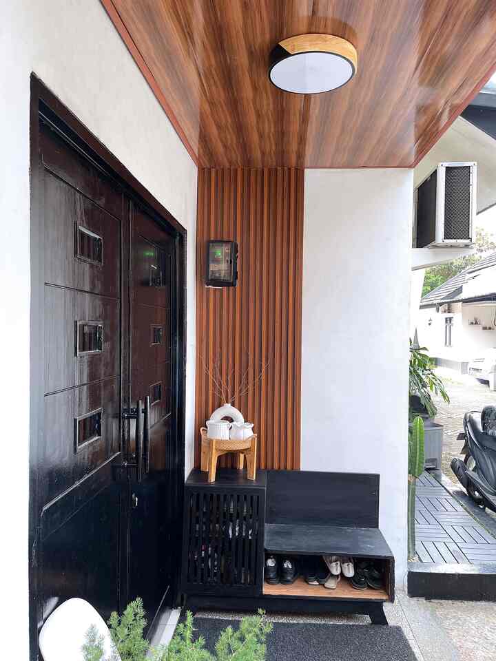 Entrance area featuring wood tone ceiling and black shoe cabinet, showcasing neat storage in a cozy entryway