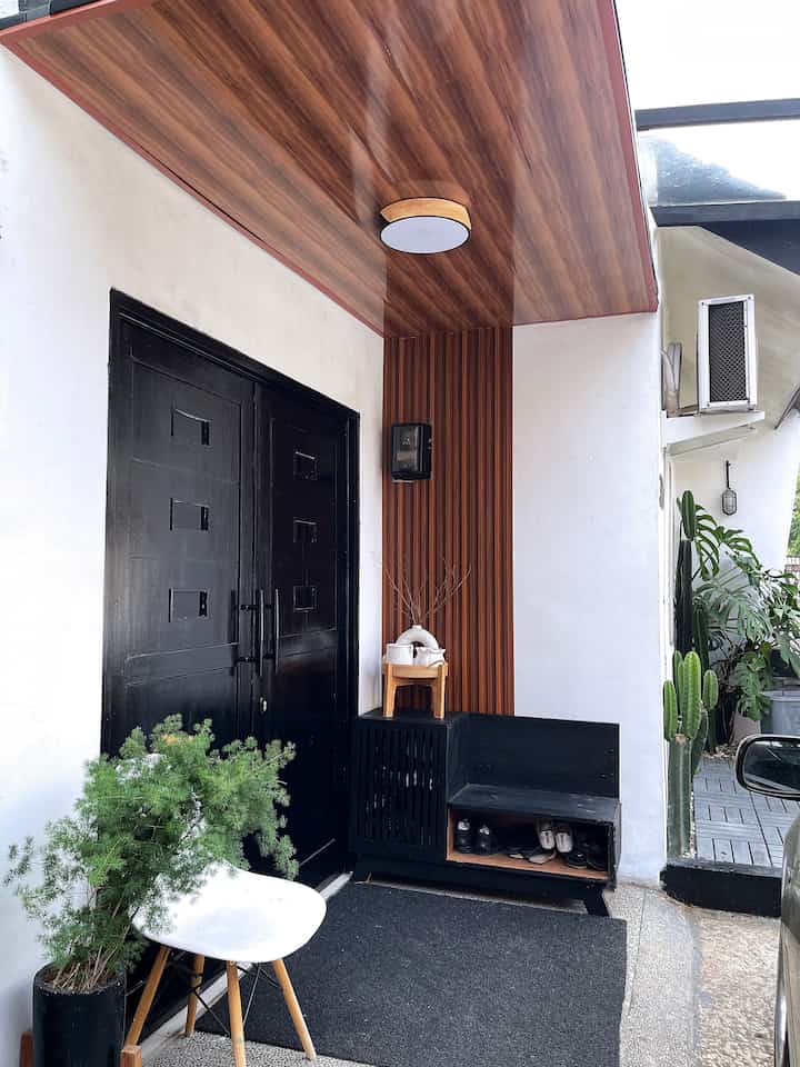 Entrance space featuring black and wood tones with a shoe storage bench creating a practical entryway