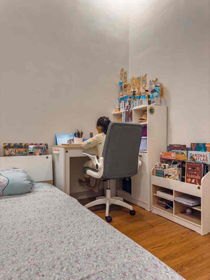 White and brown toned kids' bedroom featuring desk, chair, and toy bookshelf with cozy study atmosphere