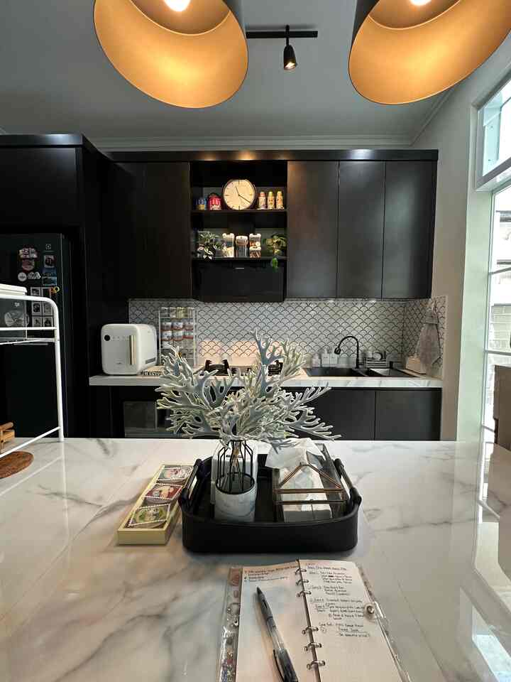 Modern kitchen with white and black tones, featuring a tray centerpiece on a marble countertop