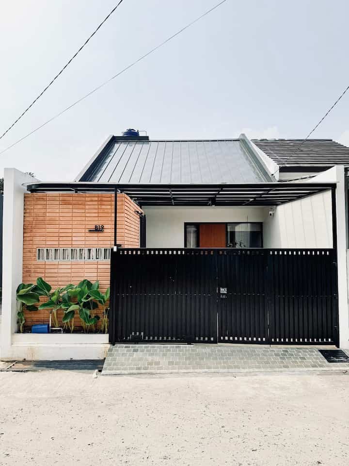 Rumah kami berada di lahan hook yang diapit oleh 2 jalan di perumahan ini, sehingga rumah kami seperti memiliki 3 fasad, yaitu tampak depan, tampak samping juga tampak belakang

Fasad depan rumah kami sangat dipengaruhi oleh adanya service room di depan rumah. Maka kami memakai material service room yang beda dan lebih menarik. Perpaduan bata tempel dan roster unfinished juga pintu geser dengan sliding besi, sangat menunjukkan kesan industrial.

Fasad juga didominasi warna hitam, baik untuk warna besi-besi hollow dan juga cat exterior pada dinding luar rumah.

Rumah ini juga tampak terlihat seperti bangunan 1 lantai, padahal kami memiliki lantai mezzanine di dalamnya

#InspirasiFasadRumah #FasadCantik #FasadRumah #desainfasad #fasadroster #fasadpagar #fasadbatatempel #fasadindustrial #japandiindustrial #fasadrumahmezzanine