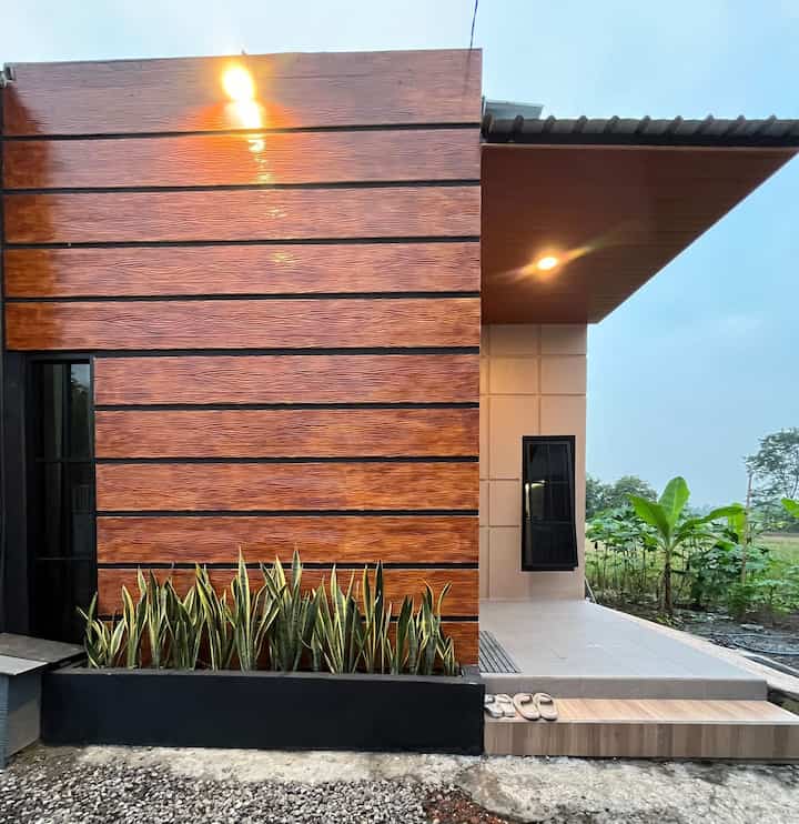 Style Fasad✨

Karena konsep rumah kami adalah rumah tumbuh, rumah yang dibangun di pedesaan diatas luas tanah yang masih sangat luas sehingga kita tidak begitu fokus dengan fasad toh nanti juga akan berganti saat kita mau memperluas bangunan. 
Tetapi sementara waktu untuk mendesain fasad kita juga mempertimbangkan estetika dan efisiensi biaya jadilah kita memilih fasad dengan style yang menurut kami bisa dibilang industrial minimalis. Dengan konsep rumah atap kotak dan menambahkan woodplank di dinding untuk menambah kesan estetik. Untuk menonjolkan style industrial nya kita memilih perpaduan warna coklat, serat kayu, dan juga hitam.
Menurut kami, style industrial ini cocok diterapkan dirumah kami yang sangat menyatu dengan alam jadi terkesan lebih estetik dengan view pemandangan alami. 
#InspirasiFasadRumah
#FasadCantik
#FasadRumah
#DesainFasad
#FasadRumah1Lantai
#FasadWoodplank