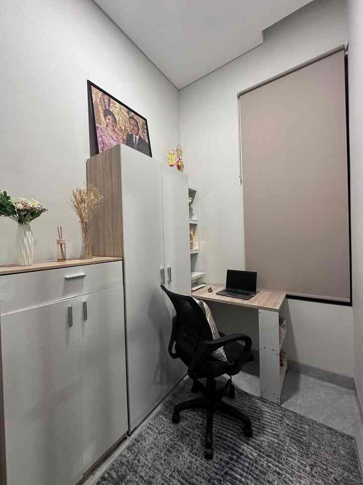 Compact home office space in white and beige tones featuring a desk and office chair, creating a clean work environment