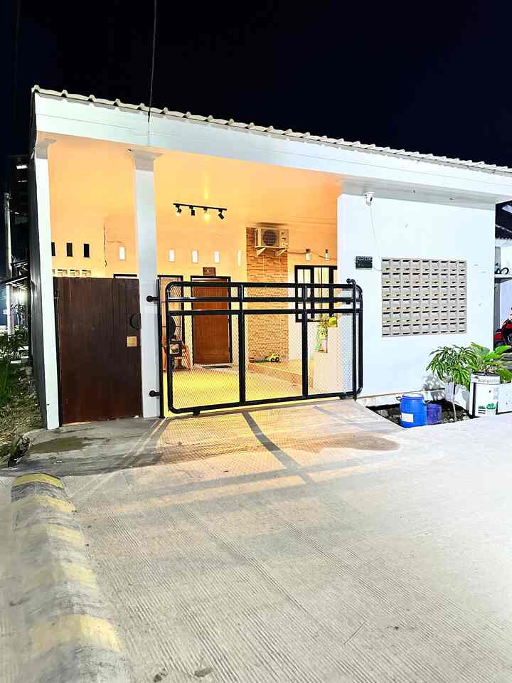 White and black toned tiny house facade featuring an industrial-style Expanda gate and ventilated roaster panel