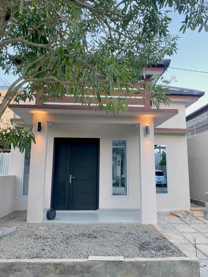 Beige and black toned detached house entrance with wall sconces and stone paving, featuring a simple and modern facade