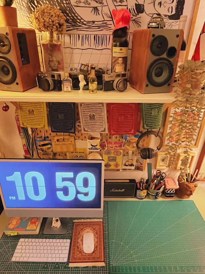 Warm orange tone home office featuring vintage speakers, cameras, and a cozy organized workspace