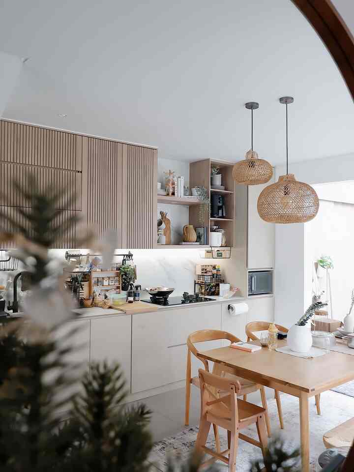 Bright natural-tone kitchen featuring rattan pendant lights and wooden table runner, creating a cozy atmosphere