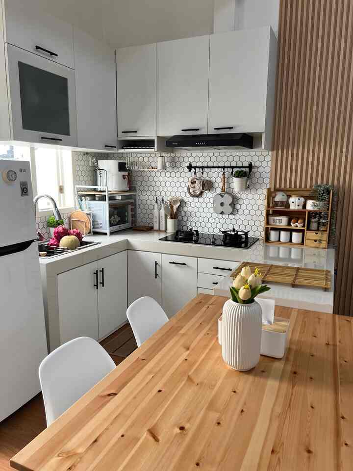 White and wood-tone U-shaped kitchen with dining area, clean and warm atmosphere