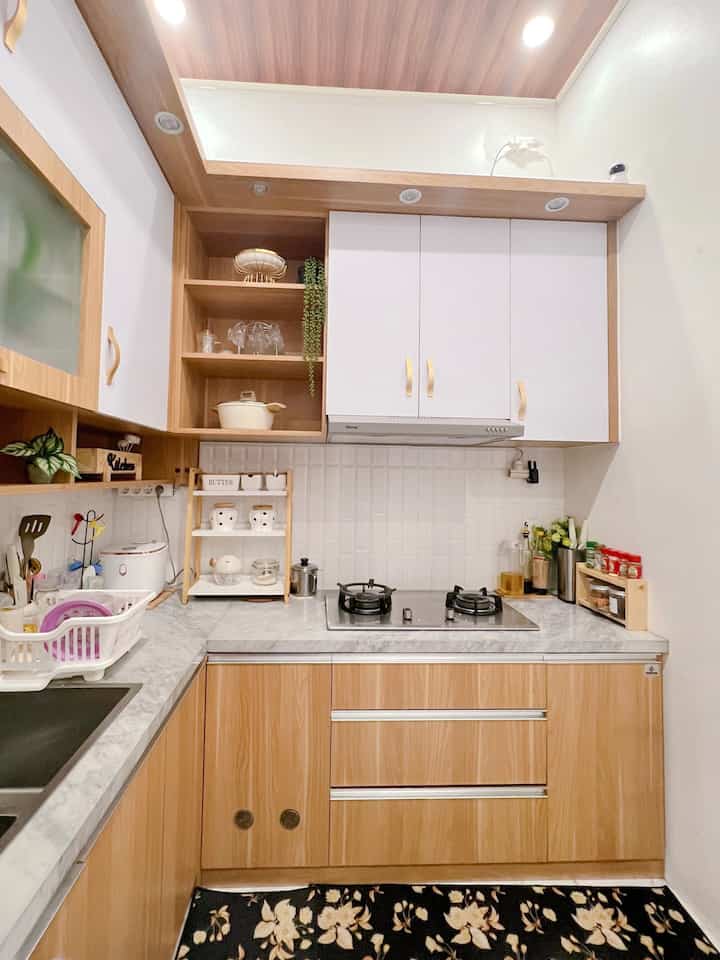 Dapur ini berwarna wood n white, karna memang dari dulu aku suka dengan tema warna ini apalagi untuk kitchen jadi seperti luas dan clean padahal ini ga terlalu luas dapurku. Ukurannya sepertinya 3x3m. 
Aku suka perintilan keramik yg sekalian bisa jd pajangan seperti yg ada di rak tingkat 3 ku itu semunga keramik, ada tempat bawang, tempat bumbu, tp tampilannya bs jadi pajangan jg kan. 

Sebisa mungkin jangan terlalu banyak menaruh barang diatas top , simpan di dalam lemari2, biar ttp keliatan lebih clean, tp kali ini barang2ku masih banyak yg terlihat karna suasana malam belum sempat untuk bebenah. 

Untuk biaya pembuatan kitchenku sendiri dulu masih 2jutaan/meter, sepertinya untuk total dengan kabinet atas bawah serta top dan kompor semuanya kemungkin 30jutaan.
Harga Semuanya tergantung ukuran dan kualitas bahan yg kita pilih, menurutku gpp pilih bahan yg lumayan pricey tp untuk jangka panjang, kalopun kita pilih yg murah nanti kalo terjadi sesuatu pasti akan mengeluarkan dana juga to. Jd itu semua kembali lg pada keputisan masing2🫶🏻

#BikinCantikDapur #MakeoverDapur #RenovasiDapur #Dapurputih #kitchenset #Kitchensetminimalis 