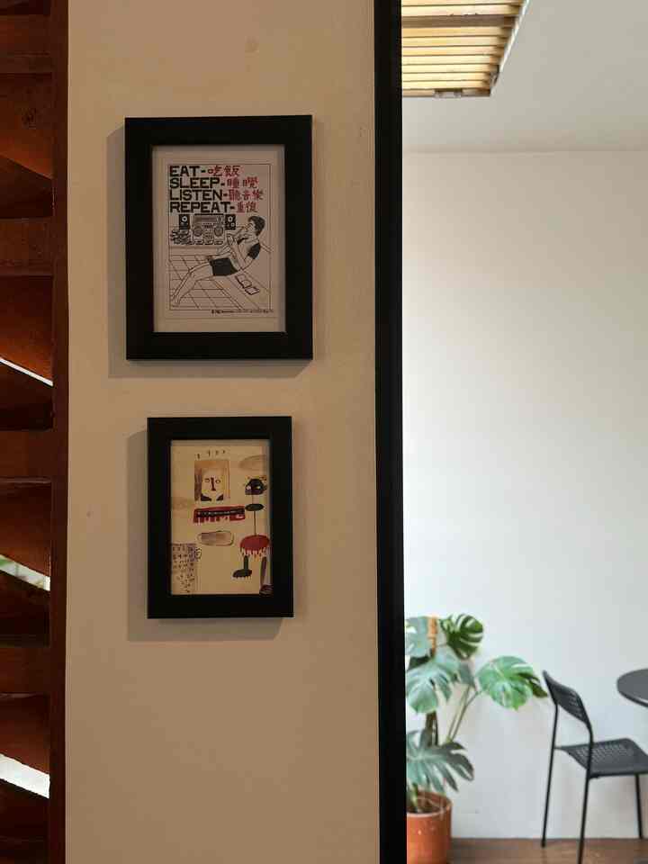 Clean interior featuring black modern picture frames on a white wall and green plant placed on the right side