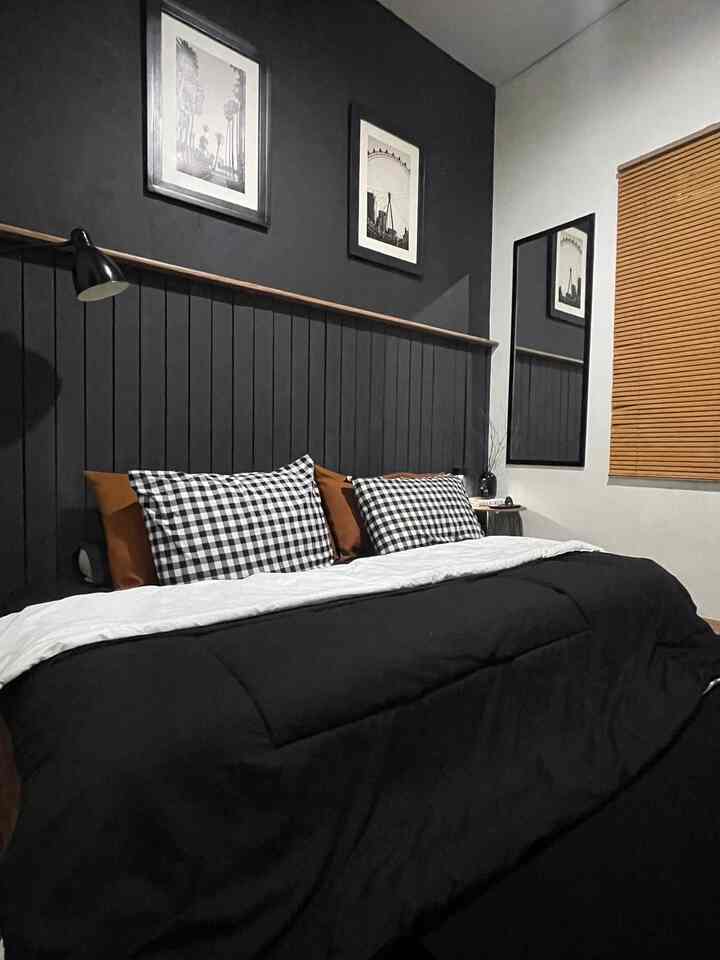 Black and white tone bedroom with checkered pillows and wooden blinds, featuring a modern and simple atmosphere