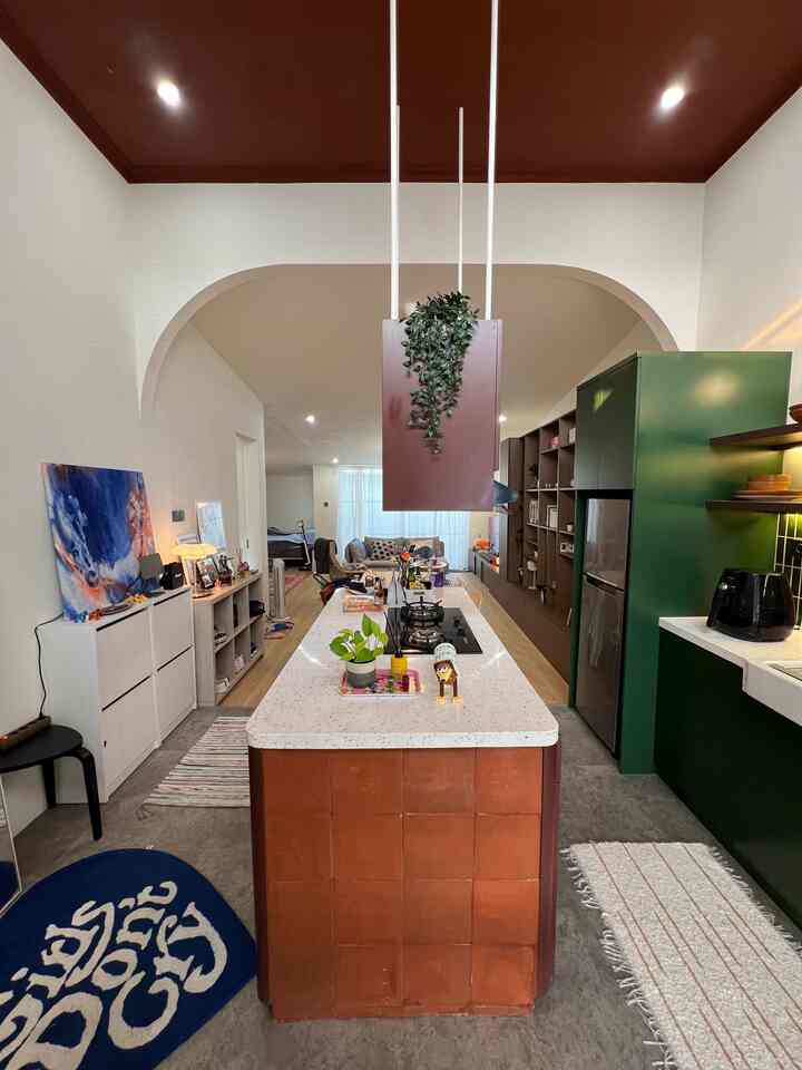 Natural color tones with green accents define a cozy connected kitchen and living room space