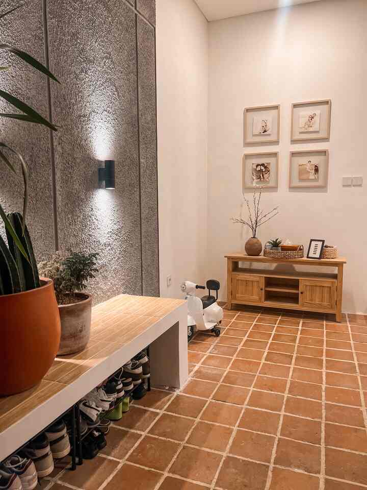 Beige and brown toned entrance featuring a bench with shoe storage and a wooden console table, creating a natural and warm atmosphere
