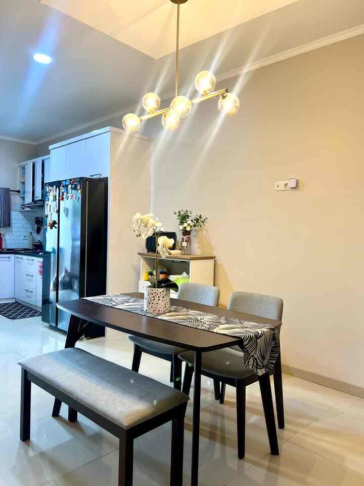 Beige-toned walls in a modern dining room featuring a dark wood dining table set under a pendant light fixture