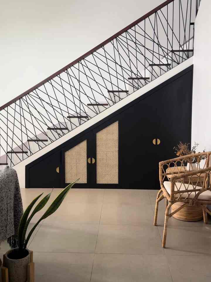 Natural toned living room with black storage cabinets and rattan chair creating a sleek modern interior