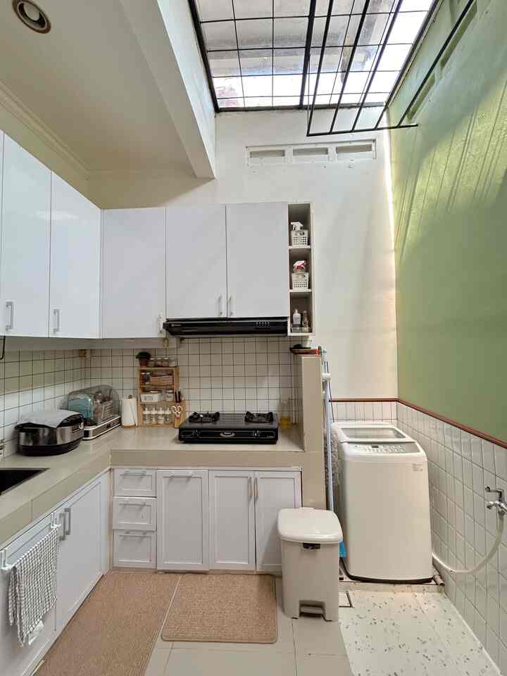 POV___ saat hanya punya sisa ruangan 3x3 m2 untuk dapur, tapi gak mau jemur pakaian di depan rumah 

Beginilah cara ku memaksimalkan lahan yg super terbatas, tapi berusaha memenuhi segala kebutuhan ku dirumah ini. Berawal dari gak suka jemur pakaian didepan rumah, dan belum ada budget untuk menambah bangunan lantai 2, jadilah dapur ini digabungkan dengan area laundry.

Mesin cuci dan kompor hanya dipisah dengan tembok yg dikeramik supaya lebih aman. Dan untuk area laundry jg dipasang keramik supaya menghindari lembab pada dinding.

Dan untuk area jemurnya, kami membuat "jemuran plafon" dari besi yg dicat warna hitam. Bagian atapnya hanya menggunakan solarflat bening yg dikombinasikan dengan list besi juga. Tujuannya supaya sinar matahari tetap bisa masuk supaya bisa jemur pakaian diruangan ini, tapi juga tidak kehujanan. 

Banyak yg tanya, "apa pakaiannya ga bau masakan?" so far, ga pernah :) karena selalu usahakan tidak pernah berbarengan waktunya masak dan jemur pakaian. Selain itu juga kita pakai lubang ventilasi jd tetap ada pergantian udara yg baik.

Kelebihan dari pemilihan tata ruang ini, yakni :
1. Hemat waktu, memasak bisa dilakukan sambil mencuci pakaian
2. Menjemur pakaian lebih santai, tidak khawatir kehujanan atau terkena debu
3. Dapur jadi terang dan hemat energi karena menyalakan lampu hanya dimalam hari
4. Dapur jadi tidak lembab

Kekurangannya, yakni :
1. Dapur jadi panas sekali kalau siang hari
2. Harus rajin dibersihkan supaya kotoran dan bau tidak mengkontaminasi pakaian yang dijemur
3. Tidak bisa masak berkali-kali karena harus menyesuaikan dengan waktu menjemur pakaian

Terlepas dari plus minus yg ada, menurut kami ini menjadi pilihan yg terbaik yg kami miliki saat ini. Jadi gimana menurut kalian?

#Ruangsempit #Ruangterbatas #NeverTooSmall 
