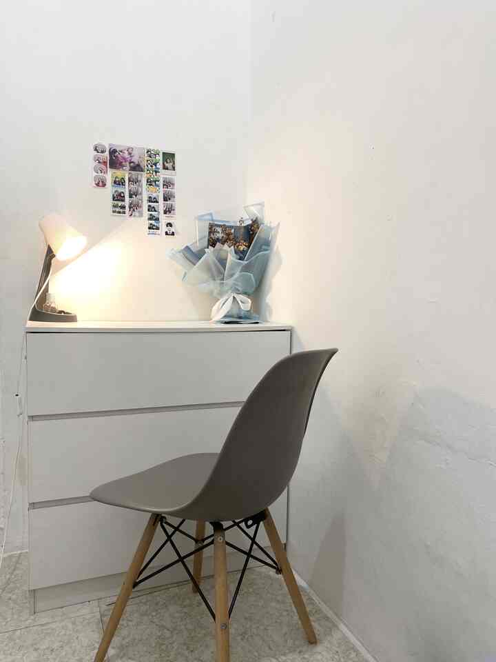 Small home office space in white and dark gray tones, featuring a simple chair and drawer cabinet with a cozy work atmosphere