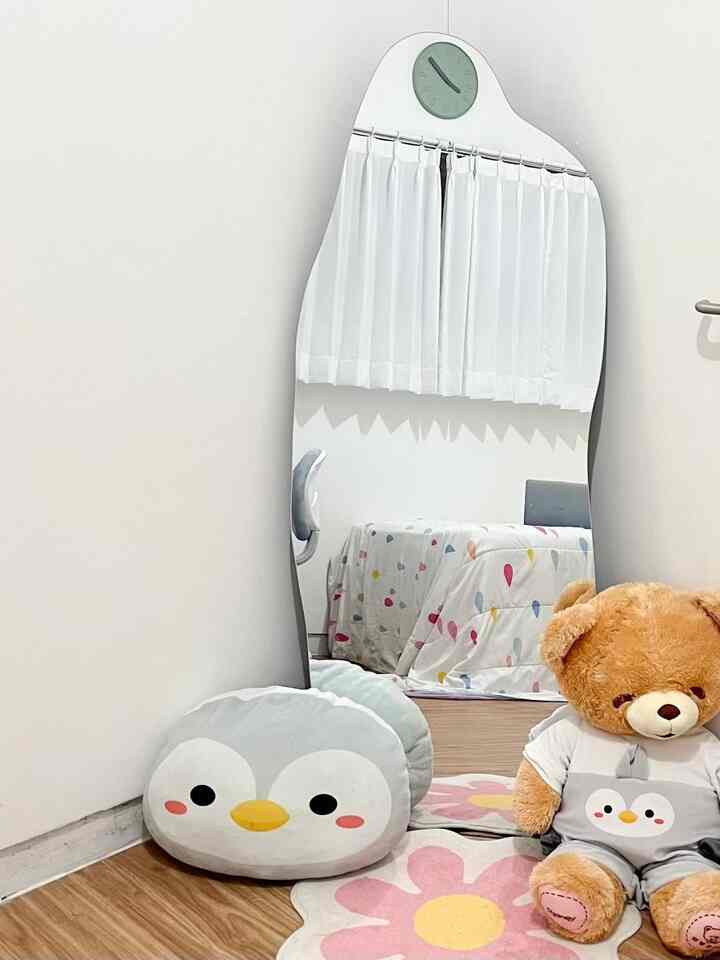 White walls and brown wood flooring define a 6-tatami bedroom featuring children's rug, cushions, and a teddy bear creating a cozy atmosphere