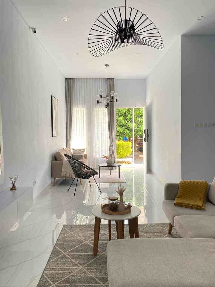 White and beige toned living room featuring minimal furniture, coffee tables, and pendant lighting with an open, spacious feel