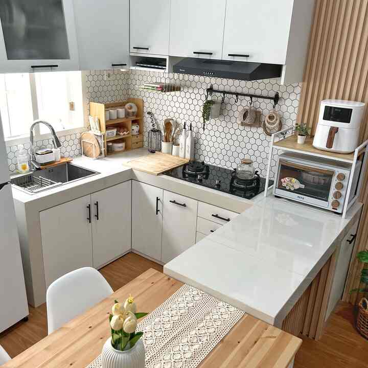 Bright white and wood tone compact kitchen featuring crochet table runner and flower vase on wooden dining table, creating cozy atmosphere