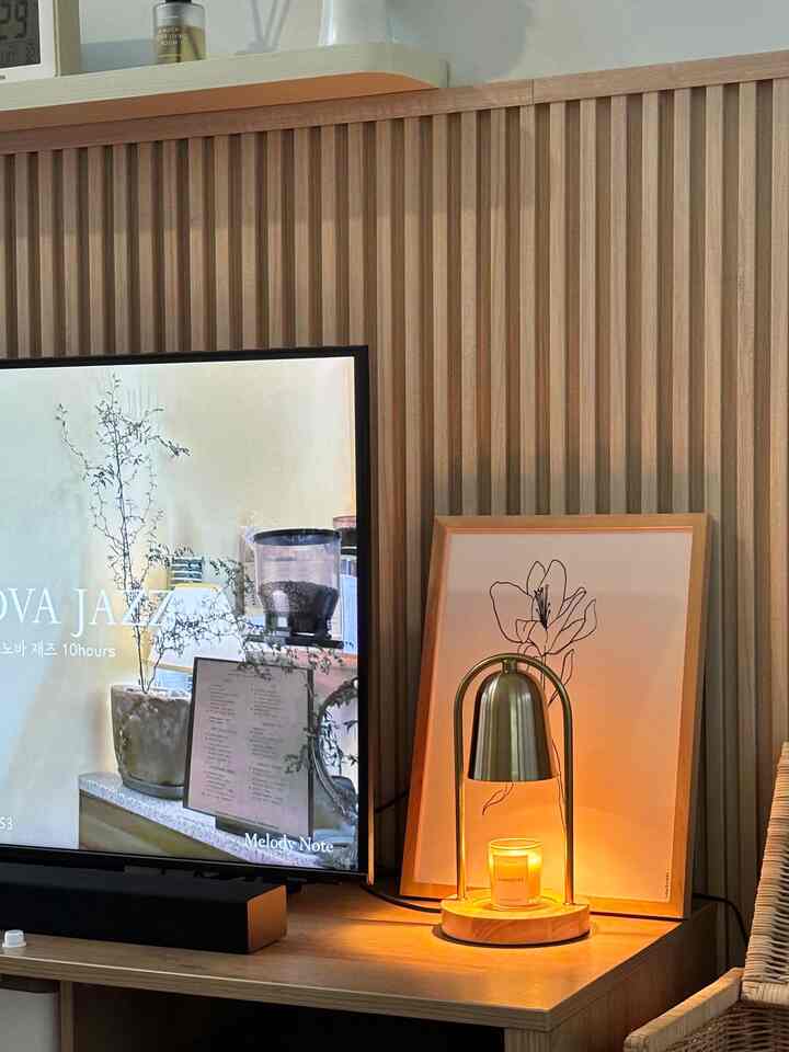 Natural wood-tone living room with TV stand and warm ambient lighting by a decorative lamp