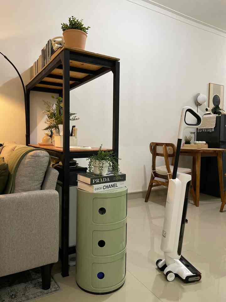 Natural-toned living room featuring a gray sofa and green round storage unit in a cozy space