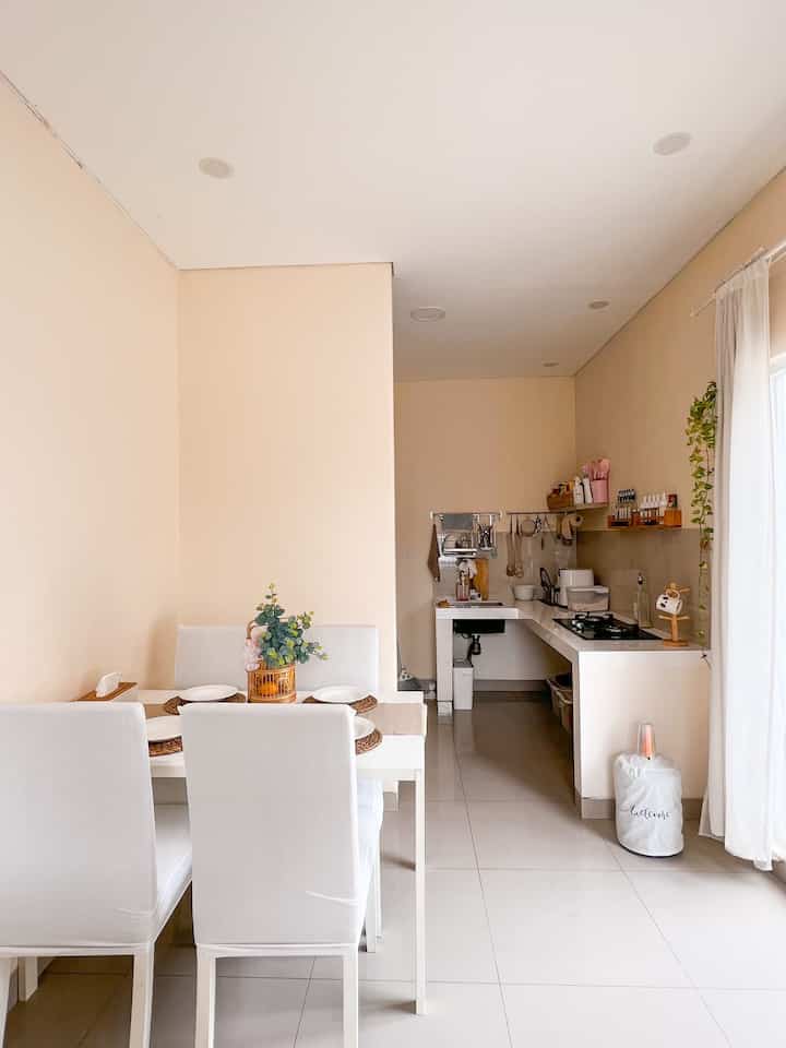 White and beige toned dining room featuring a simple dining table with chairs in a cozy setting
