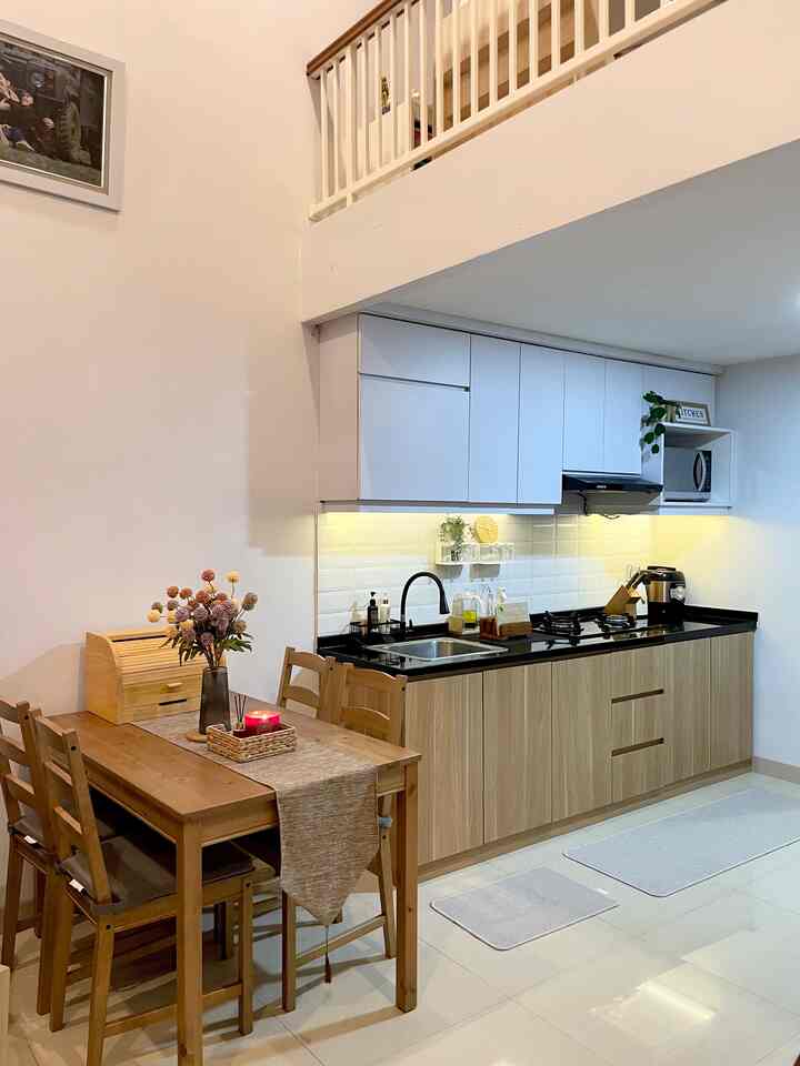 Bright white and natural wood tone kitchen with a 4-person dining table arranged in a clean, orderly space