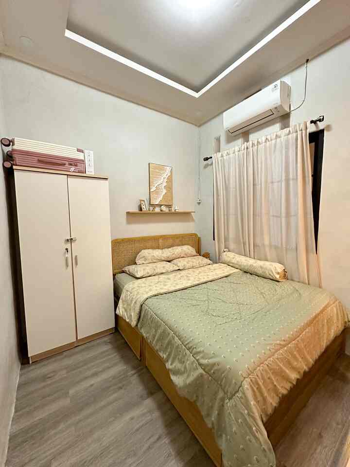 Natural color bedroom featuring a wood-tone bed and closet, creating a calm and cozy atmosphere