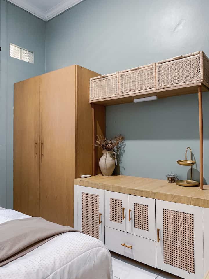 Blue-toned walls with natural wood furniture and rattan storage baskets in a harmonious bedroom space