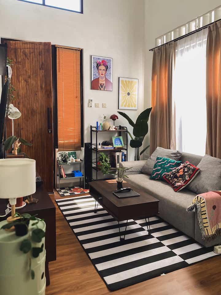 Natural brown and gray toned living room featuring a sofa and striped carpet, creating a warm and cozy atmosphere