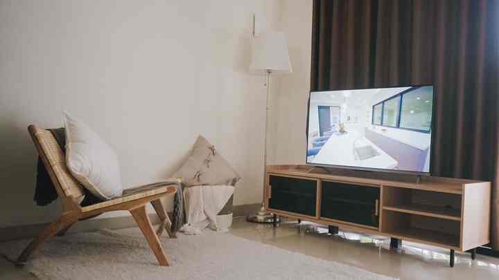 Natural modern small living room featuring a lounge chair and TV stand with a cozy atmosphere