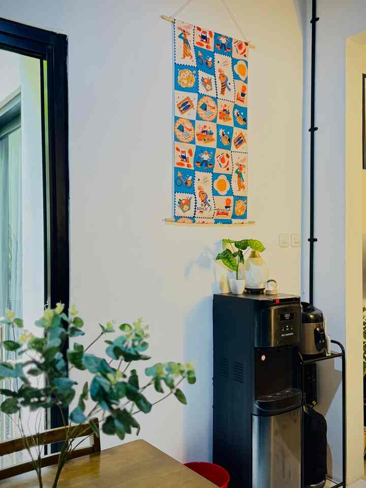 White walls with black kitchen appliances including a dining table and diffuser create a cozy kitchen space