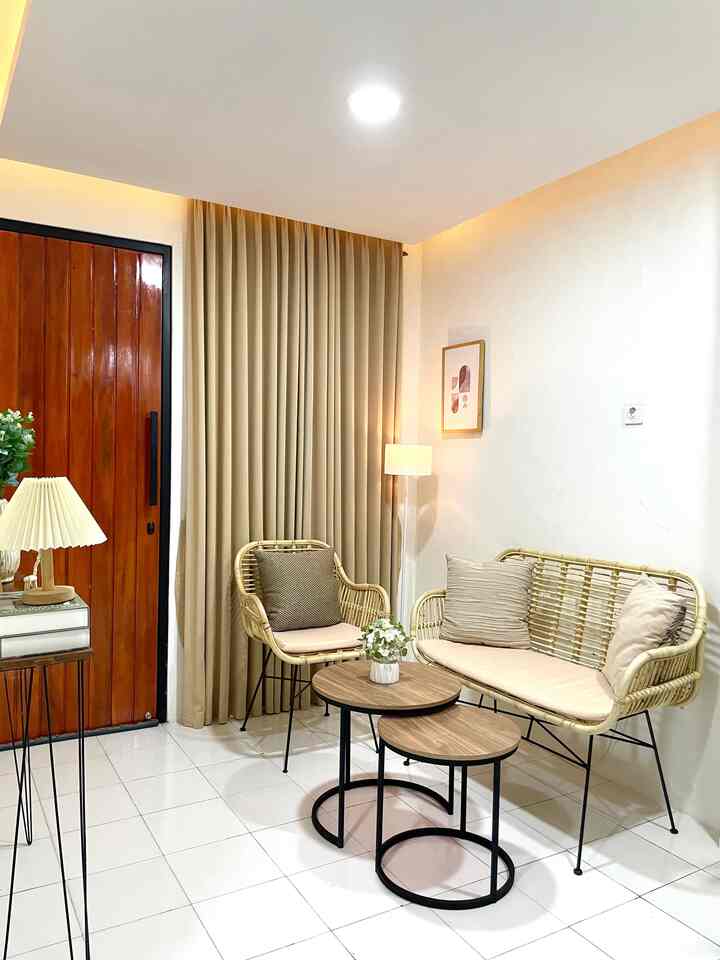 Natural beige-toned living room featuring rattan furniture and round coffee tables with a simple, spacious interior