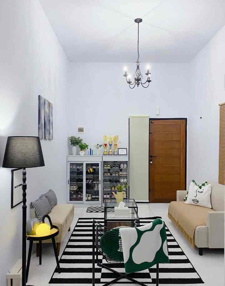 Simple white and black living room featuring beige sofas and an armchair, creating a cozy atmosphere