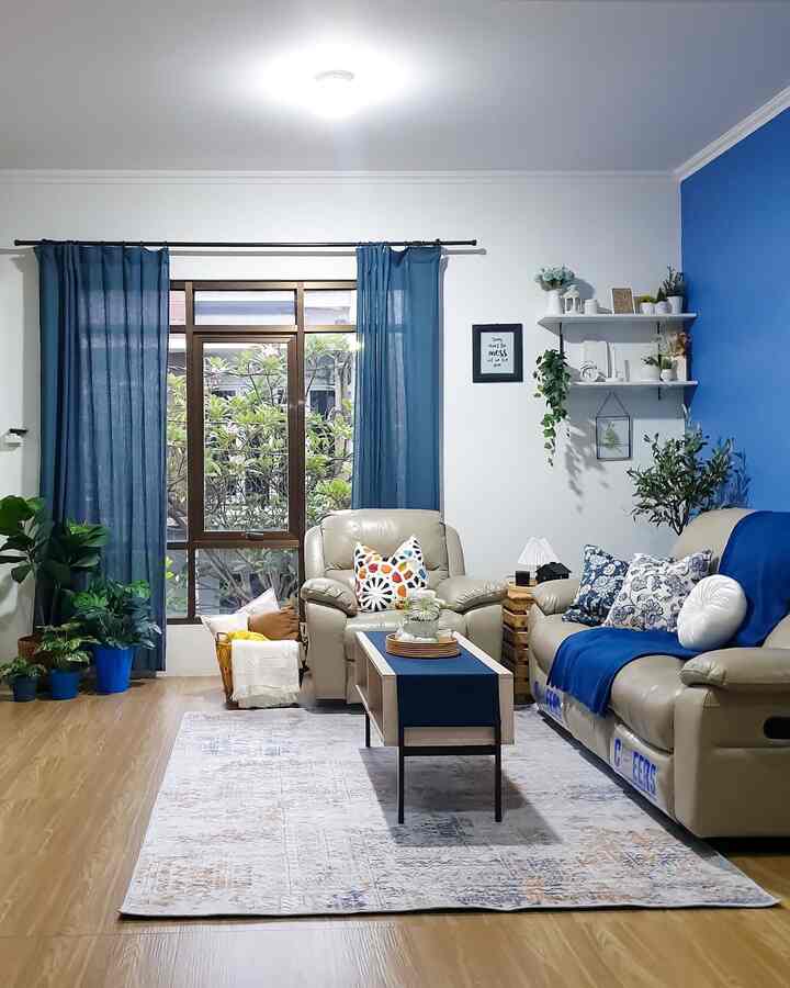 -unsur biru di living room-

warna utama cat di rumah ini adalah paduan putih dan biru. warna ini kita pilih secara adil dimana si ibok pengennya rumah dengan warna putih, sementara paksu yg tidak ingin monoton putih, menambahkan unsur biru di beberapa titik, termasuk di living room ini. 

ambience yang ingin dimunculkan di ruang ini adalah homey. karena di living room ini lah interaksi kami sekeluarga terbangun, tempat yg paling sering membuat kami berkumpul. selain itu, kami pun ingin tamu yg datang ikut merasa suasana homey jika sedang ada di ruangan ini. 

untuk mewujudkannya, disini kami menggunakan sofa, karpet dgn motif minimalis, menambahkan bantal2 dan throw. agar suasana dalam ruangan ini berkesan segar, kami letakkan tanaman2 hijau artificial. sementara untuk printilan dekorasinya kami bermain aman pada warna2 putih/hitam dan unsur kayu. agar kesan warm-nya muncul, maka untuk lantai kami pilih granite motif kayu. 
furniture dan benda2 dekorasi di ruangan ini kebanyakan kami beli di toko yg sudah dikenal umum  dan ada di berbagai daerah di Indonesia. selain itu, beberapa barang juga dicari melalui market place. 

gimana nih menurut tetangga, sudah dapet belum unsur homey di living room ini? 😁🤗 


#livingroom #livingroomstyling #dekorasilivingroom 
#livingroommakeover #ohouseseason8