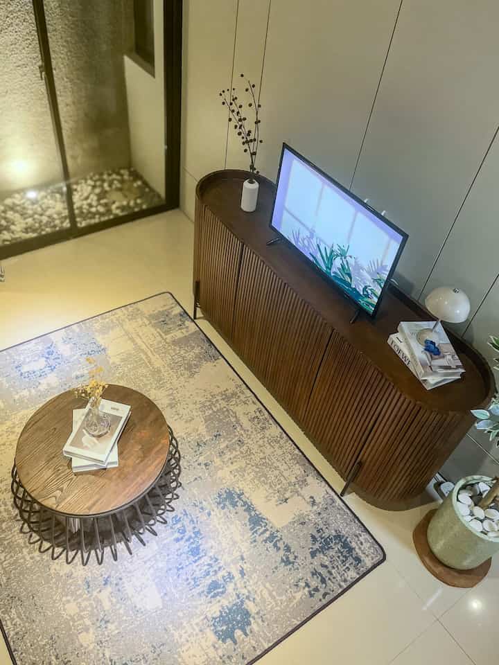 Ruang Tamu Nyaman: Menjadi Tempat Berkumpul Favorit di Rumah

Pernahkah Anda membayangkan memiliki ruang tamu yang begitu nyaman sehingga Anda betah berlama-lama di sana? Kali ini aku mau kasih tau cara menjadikan ruang tamu sebagai tempat favorit keluarga dan tamu.

Fokus utamanya adalah pada credenza jati yang digunakan untuk meja TV. Selain untuk dijadikan TV stand, credenza ini juga memberi statement pada ruangan. Ditambah lagi motif panel dinding minimalis yang membuat area ruang tamu terlihat menonjol. Di atas credenza saya letakkan lampu jamur, buku tiruan, dan tanaman hias kecil-kecil agar suasana semakin nyaman. Kabel-kabelnya sangat rapi, semuanya muat dalam kotak besar yang bisa memuat stopkontak dan adaptor wifi.

Lanjut ke meja tamu, saya memilih meja kayu dengan rangka besi multifungsi. Selain bisa untuk membuat kopi, meja ini juga berfungsi sebagai tempat menyimpan buku sehingga rapi dan mudah diambil saat ingin membaca.

Semua furnitur dan dekorasi ini saya pilih agar ruang tamu tidak hanya enak dipandang, tapi juga nyaman bagi semua orang di rumah. Lemari credenza saya custom, tapi banyak furniture lainnya yang saya dapatkan dari toko online. Jadi, bagaimana menurut Anda? Bisakah Anda bayangkan membuat ruang tamu seperti ini?

#LivingRoomStyling #DekorasiLivingRoom #LivingRoomMakeOver #LivingRoomGoals #HomeDecorInspiration #CozyLivingRoom #InteriorDesign #MinimalistDecor #JapandiStyle #HomeMakeover #FurnitureInspiration #CustomFurniture