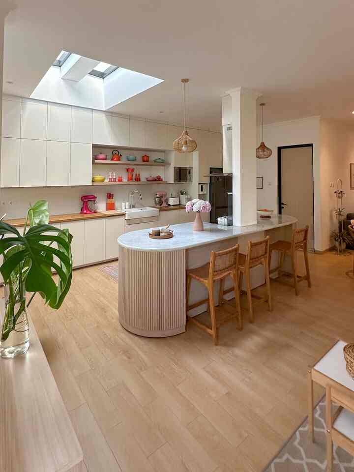 Bright kitchen in white and wood tones featuring a kitchen island and skylight, creating a natural and airy atmosphere