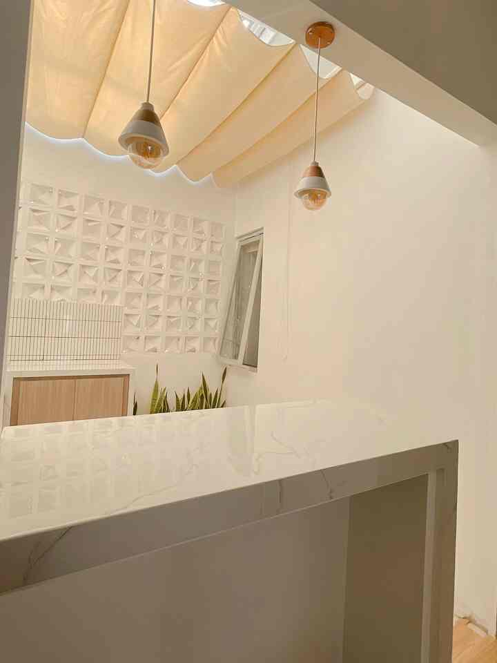 Simple dining room in white and beige tones featuring a marble dining table and pendant lights with a cozy atmosphere