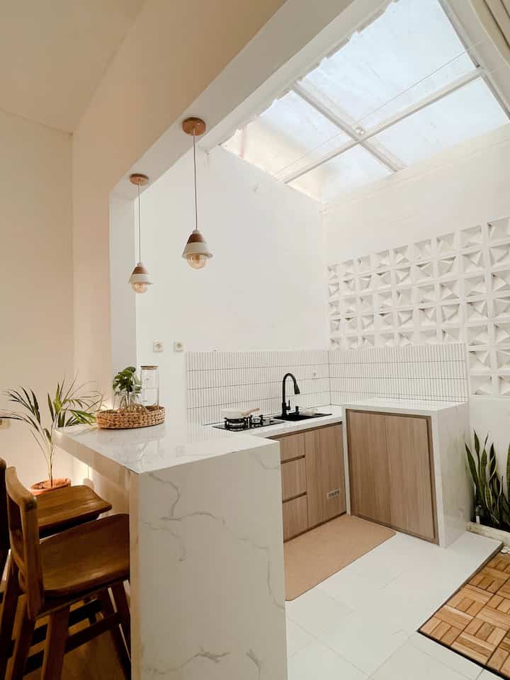 Bright kitchen with white and wood tones, featuring a skylight and pendant lights creating a natural, airy atmosphere