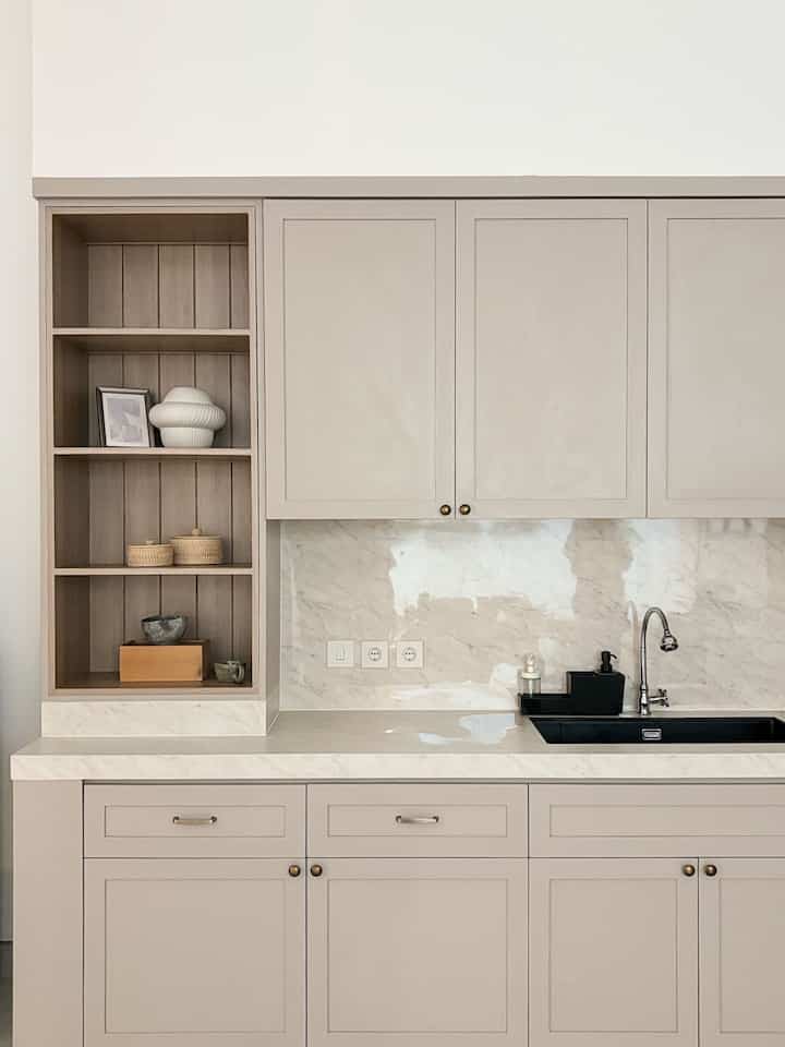 Beige and gray toned kitchen featuring sleek cabinets and black sink in a modern, clean space