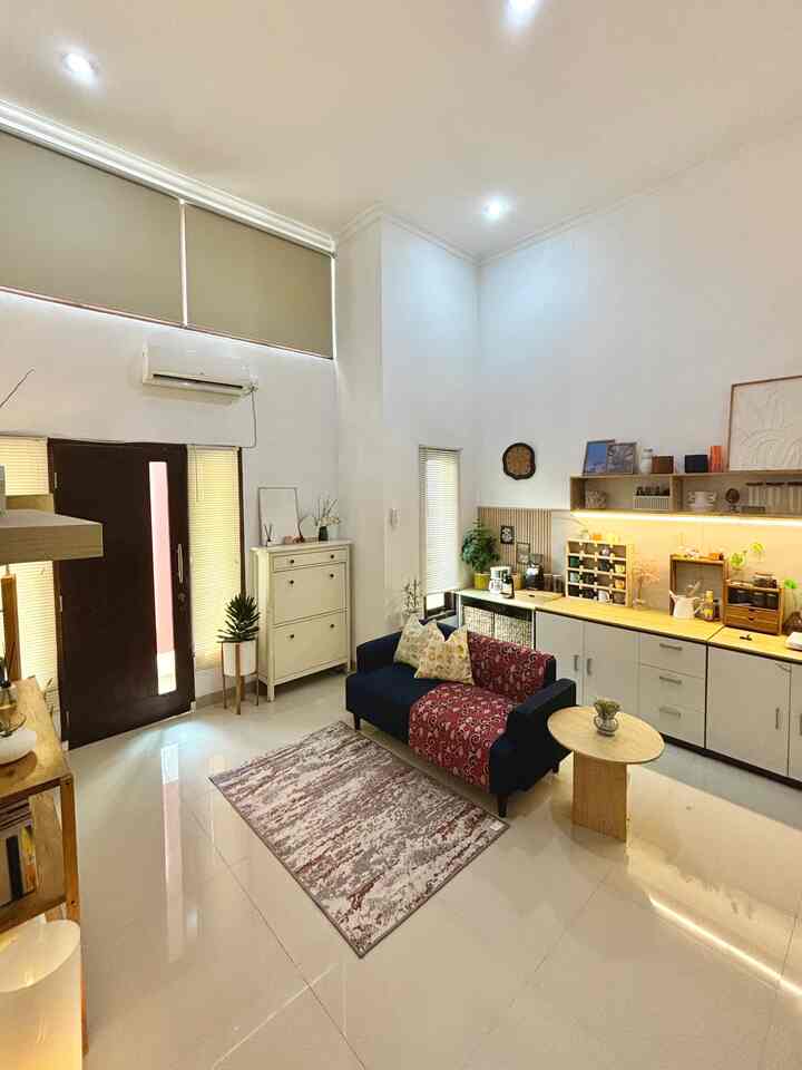 Bright living room with white and wood tones, featuring a navy sofa and beige blinds in a clean modern design
