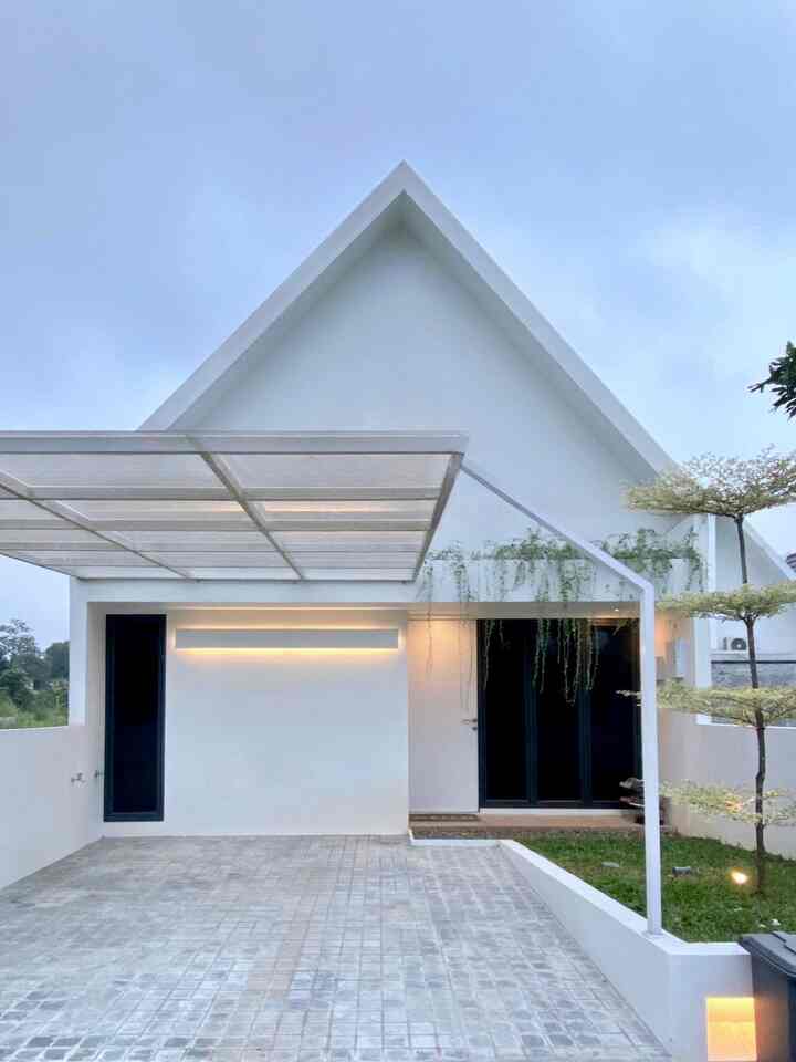 Inilah wujud fasad bawaan dari developer yang membuat kami langsung jatuh hati; sederhana dan seamless. Tidak banyak perubahan yang kami lakukan pada bagian fasad ini, hanya penambahan kanopi, serta perluasan dan penggantian lantai carport. 

Untuk kanopi, kami memilih menggunakan atap solartuff clear. Ternyata hal ini cukup tricky karena gampang kotor dan perlu effort membersihkannya. Selain itu, karena dibangun sebelum perluasan carport, alhasil tiang kanopi ini harus dibongkar dan digeser. Kami pun mengakali dengan mengubah tiangnya menjadi bentuk segitiga alias sudut pelana, supaya lebih kokoh menopang atap kanopi.

Untuk lantai carport yang awalnya hanya berupa semen biasa, kami ubah menjadi batu andesit untuk mempertahankan kesan natural.

#FacadeStyle #MaterialFasad #InspirasiFasad