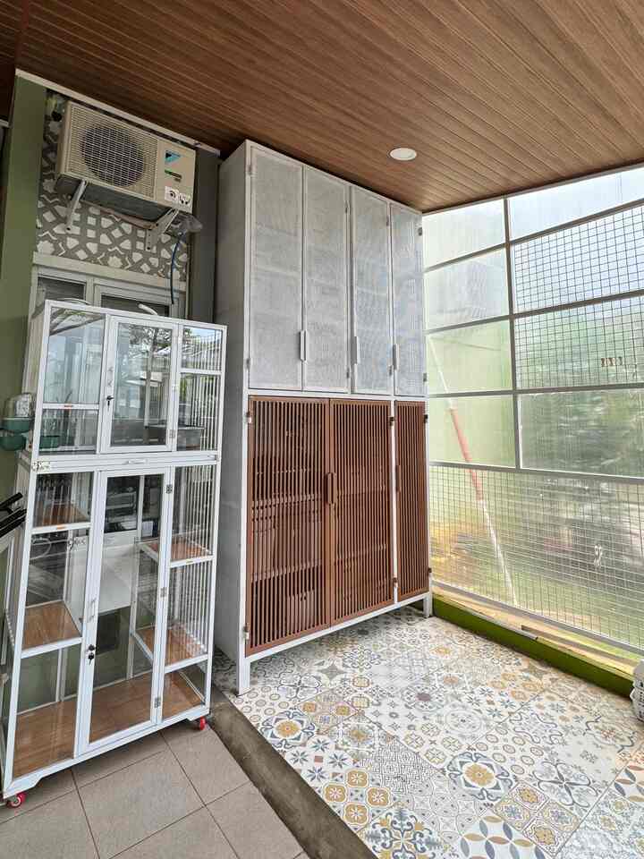 Natural wood tone ceiling and white-brown pet house storage cabinets in a bright balcony space