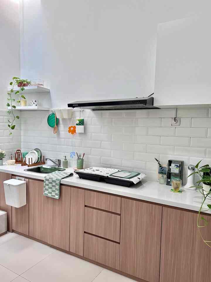Clean, minimal kitchen with white walls and subway tiles, featuring wood-tone lower cabinets