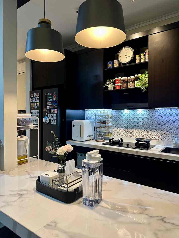 • Kitchen-Dining Room Material •

Hello O!House friends, the kitchen in my house is integrated with the dining room with a table made of cast/concrete and a granite tile finishing measuring 60x120cm. For both tables I used the Sandimas brand, Statuario Grey type.

For the backsplash, I used a mermaid/fish scale/fan shaped mosaic tile in white.

My kitchen set cabinet uses Aluminum Composite Panel (ACP) material with plywood doors with a black HPL finishing (Taco TH 205 B - Asian Beech). I don't use handles but only finger groove accents.

The walls match the overall interior of the house, using the Catylac brand in Seamist color.

As for the floor, I chose rough textured ceramics with a terrazzo motif from Platinum, Dexter type, measuring 50x50cm (matte).

I chose all of these materials because they are low maintenance and most importantly because I like all the motifs, textures and finishing looks they produce. 🩵 #MyDreamKitchen #KitchenDecorIdeas #KitchenMaterials #ModernKitchen #SleekDesign