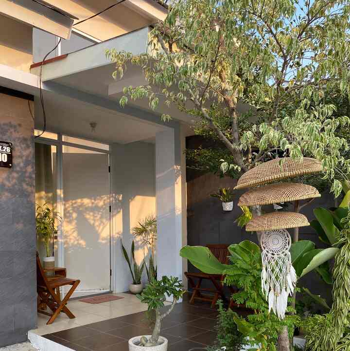 Fasad rumah cluster ini kami renovasi dengan menambahkan plafond gypsum dan lantai yang bertekstur natural agar kontras dengan warna plafond. Untuk menambah kesan asri dan teduh, pohon Ketapang Kencana kami tempatkan persis di depan teras rumah. Teras kami juga berfungsi sebagai ruang tamu yang dilengkapi kursi kayu sebagai unsur etnic Jawa.
#FacadeStyle #MaterialFasad
#InspirasiFasad #tinyhouse #exterior #rumahcluster